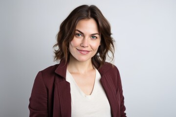 Obraz premium Portrait of a smiling businesswoman standing against gray background. Looking at camera