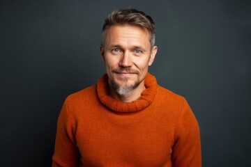 Fototapeta premium Portrait of a middle-aged man in an orange sweater.