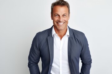 Fototapeta premium Handsome middle-aged man smiling at camera while standing against grey background