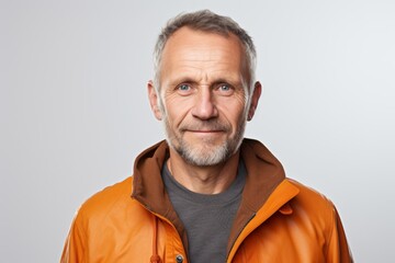 Obraz premium Portrait of a senior man in an orange jacket on a white background