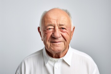 Portrait of a senior man with wrinkles on his face on grey background