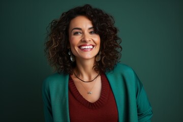 Portrait of a beautiful young woman with curly hair against green background