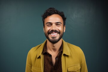 Portrait of handsome young man smiling at camera against green chalkboard