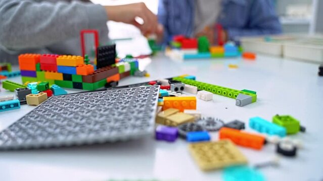 Robotics programming class. Children construct and code Robot. STEM education using constructor blocks and laptop tablet, remote control joystick. Technology educational development for school kids