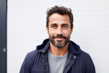 Obraz premium Portrait of handsome man smiling at camera in front of white wall