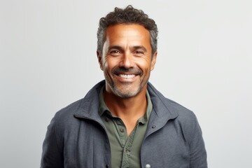 Portrait of a handsome mature man smiling at the camera against grey background
