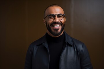 Fototapeta premium Portrait of a smiling african american man in black jacket and glasses