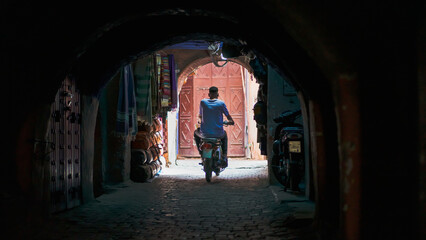 Fototapeta na wymiar Marrakesh. Motorcycle riding in small alley. 