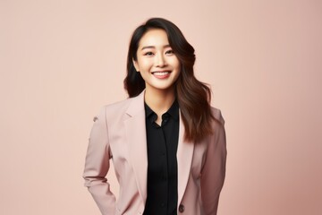 Portrait of a smiling young business woman standing isolated over pink background