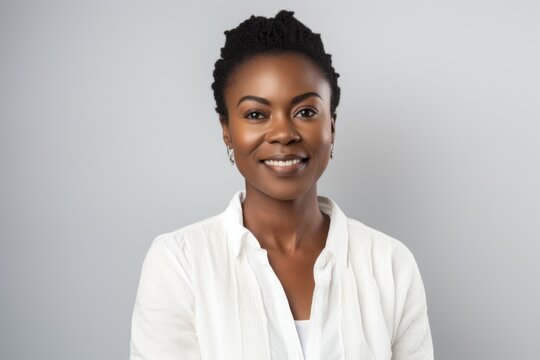 Smiling African American Woman In White Shirt On Grey Background