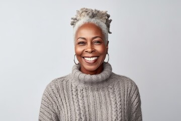Medium shot portrait photography of a satisfied Nigerian black woman in her 50s wearing a cozy sweater against a white background 