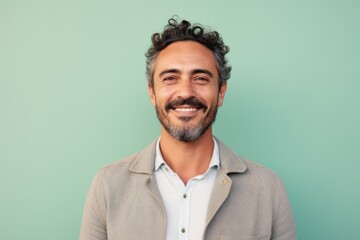 Fototapeta premium Portrait of a handsome man with curly hair on a green background