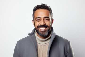 Portrait of a handsome Indian man smiling at camera over white background