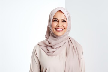Portrait of happy muslim woman in hijab looking at camera over white background