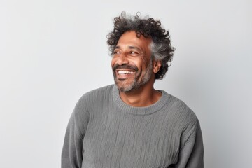 Obraz premium Portrait of a happy middle-aged Indian man with curly hair smiling at the camera.