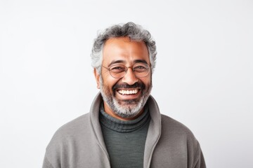 Portrait of a happy mature Indian man smiling at camera isolated on a white background
