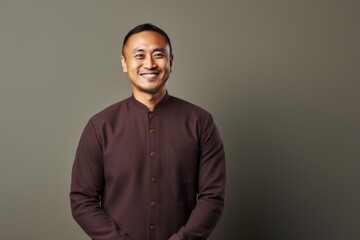 Obraz premium Portrait of a smiling young asian man wearing a brown shirt