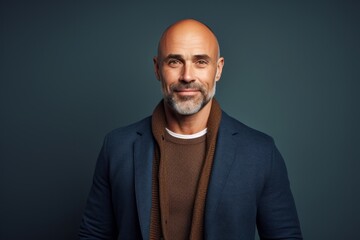Fototapeta premium Handsome mature man looking at camera and smiling while standing against grey background