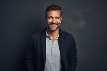 Obraz premium Portrait of a handsome man looking at camera and smiling against grey background