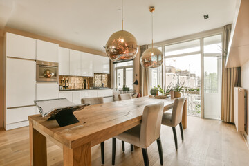a kitchen and dining area in a modern home with wood floors, white cabinets and an open - plan living room