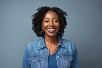 smiling african american woman in denim jacket on grey background
