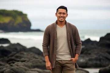 Portrait of a handsome young asian man standing on the beach