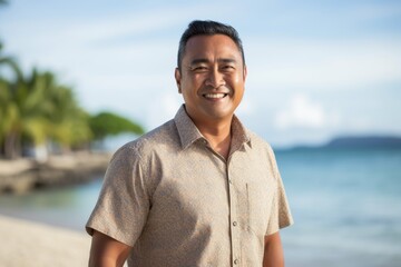 Portrait of happy asian man standing on the beach and smiling