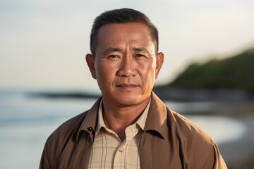 Portrait of a mature Asian man looking at camera on the beach