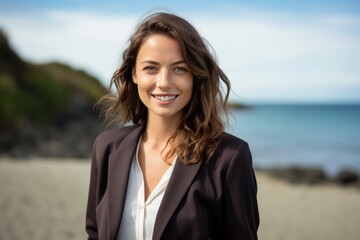 Portrait of a smiling young businesswoman standing on the beach at the day time