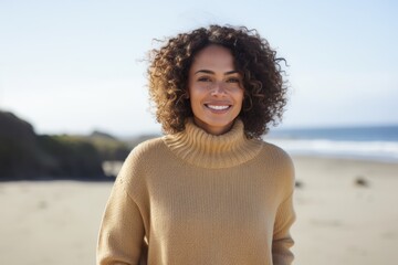 Portrait of smiling young woman standing on beach on an autumns day