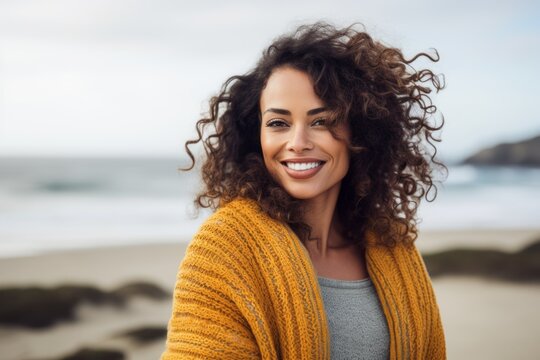 Portrait of a smiling young woman with curly hair at the beach