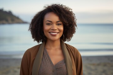 Portrait of smiling african american woman on beach at sunset
