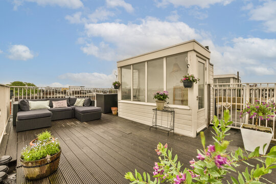 a roof deck with flowers and potted plants in the fore - image was taken from an outside viewing point