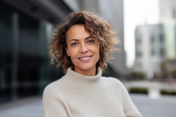 Fototapeta premium Portrait of a beautiful young woman with curly hair smiling at the camera