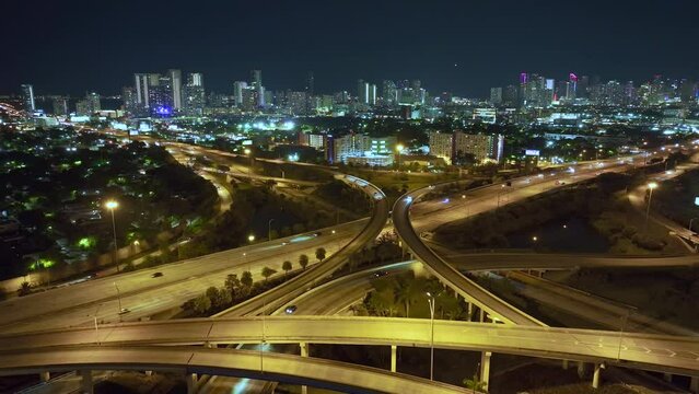 View from above of USA transportation infrastructure. Aerial view of american highway junction at night with fast driving vehicles in Miami city, Florida