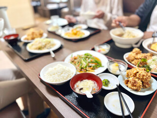 中華定食が並んだテーブルと人の手