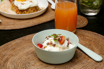 Greek yoghurt in a bowl with fruit slices and honey