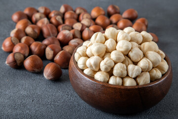 Heap of peeled and shelled hazelnuts on dark background