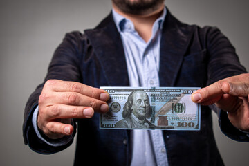 Hombre sosteniendo billete de 100 dolares