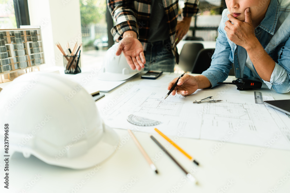 Poster two engineer working to discuss and brainstorming about blueprint of construction project in office
