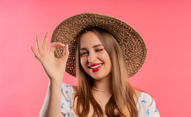 Pretty woman with OKAY sign, ok gesture. Happy lady, correct choice on pink wall