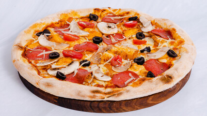 Pizza with sausages, ham and olives
