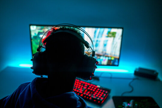 Teenager Playing Video Games on PC, Red Lit Keyboard