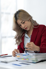 Businesswoman working in piles of paper files Data graph document to find and review cleared tasks still backlog. unsuccessful folder documents at office desk