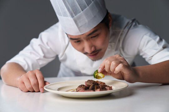 Middle-aged man in chef's uniform prepares delicious food