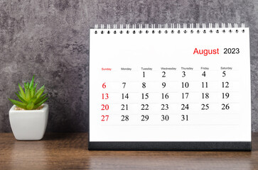 The August 2023 Monthly desk calendar for 2023 year on wooden table.
