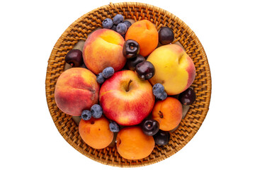 Fresh sweet fruits in a ceramic plate on a white background, macro, top view.