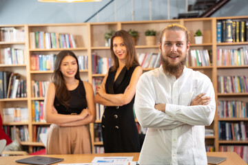Portrait of business man standing in front of team looking to camera with smiling. He success with business deals with team.