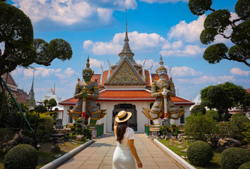 The tourist woman standing over the main entrance of the Temple of Wat Arun 
