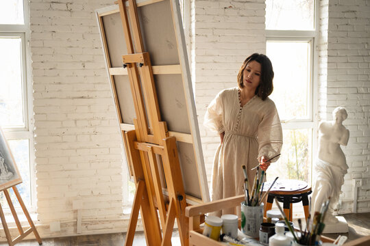 Young female painter painting in a studio